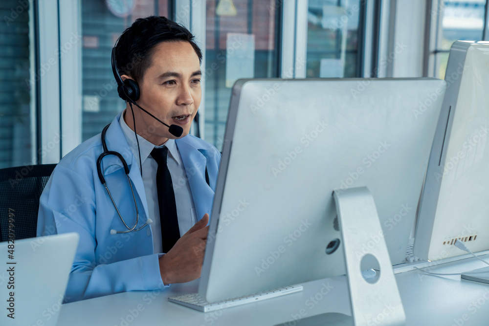 Doctor wearing headset talking actively on video call in a clinic or hospital . Concept of telehealt