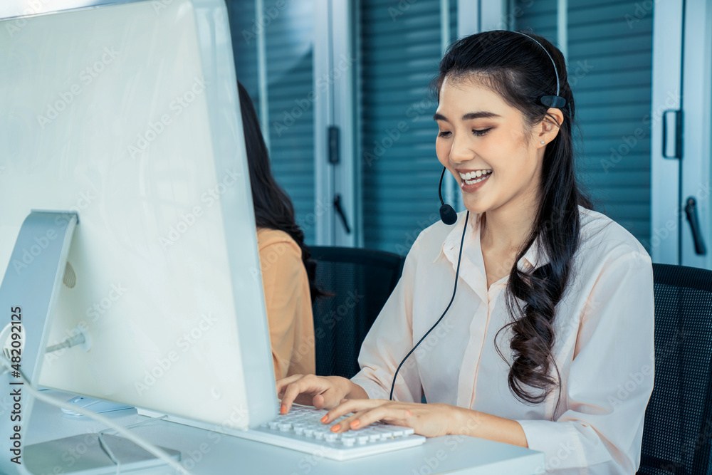 Businesswoman wearing headset working actively in office . Call center, telemarketing, customer supp