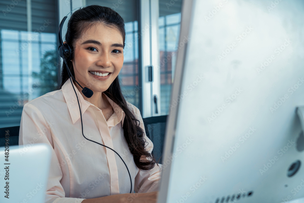 Businesswoman wearing headset working actively in office . Call center, telemarketing, customer supp