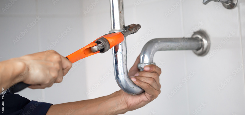 plumber at work in a bathroom, plumbing repair service, assemble and install concept.