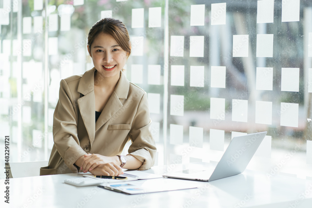 年轻的亚洲女性在家学习时记笔记并使用笔记本电脑，女性在客厅放松