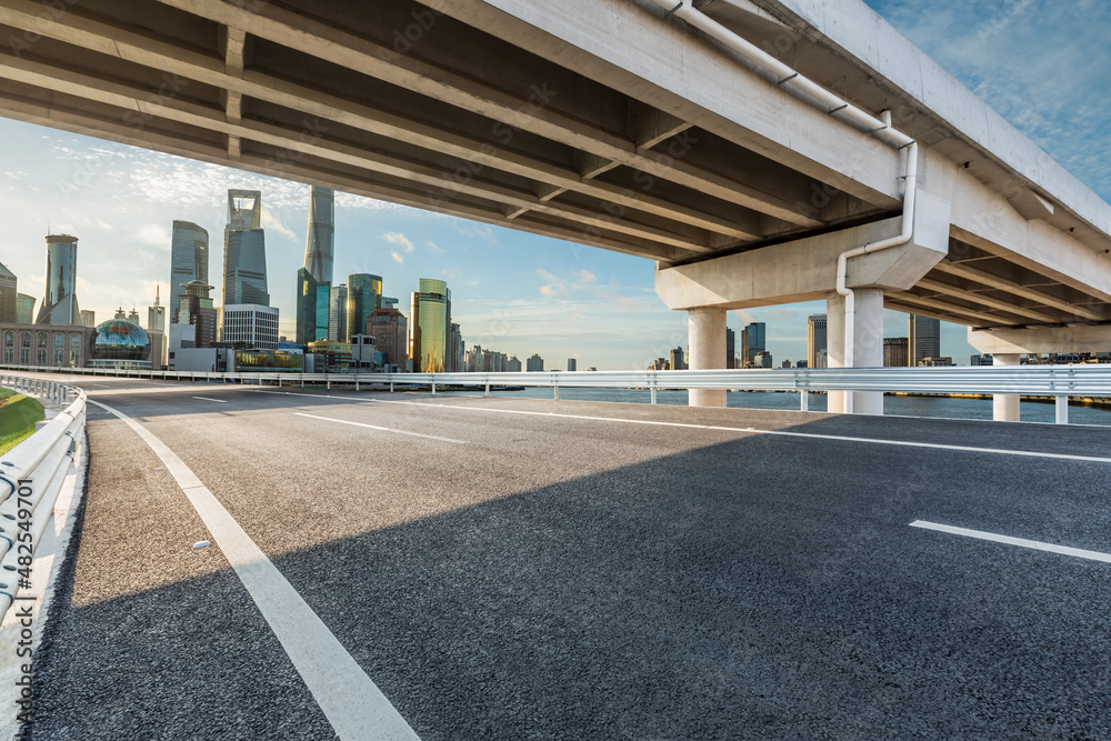 中国上海，空旷的柏油路和拥有现代商业建筑的城市天际线。