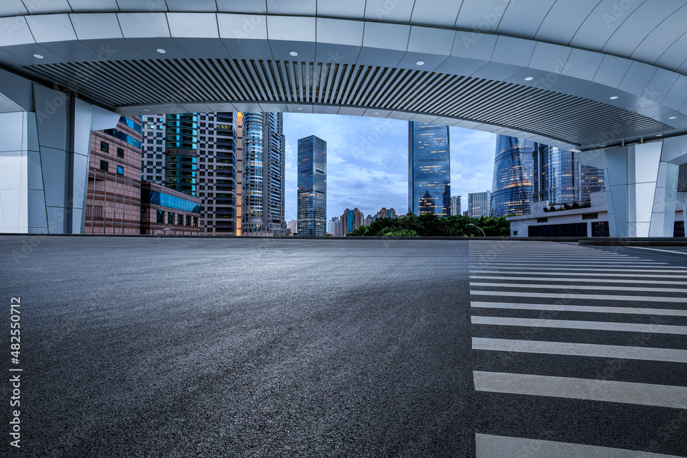 中国上海，空旷的柏油路和拥有现代商业建筑的城市天际线。