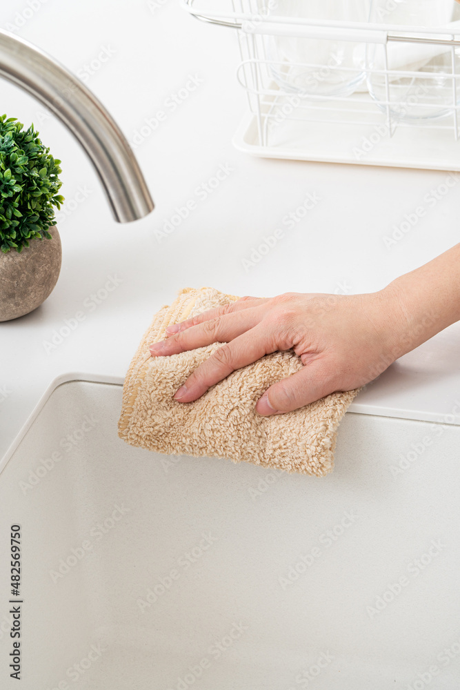 Woman housewife is doing the spring cleaning at home kitchen.