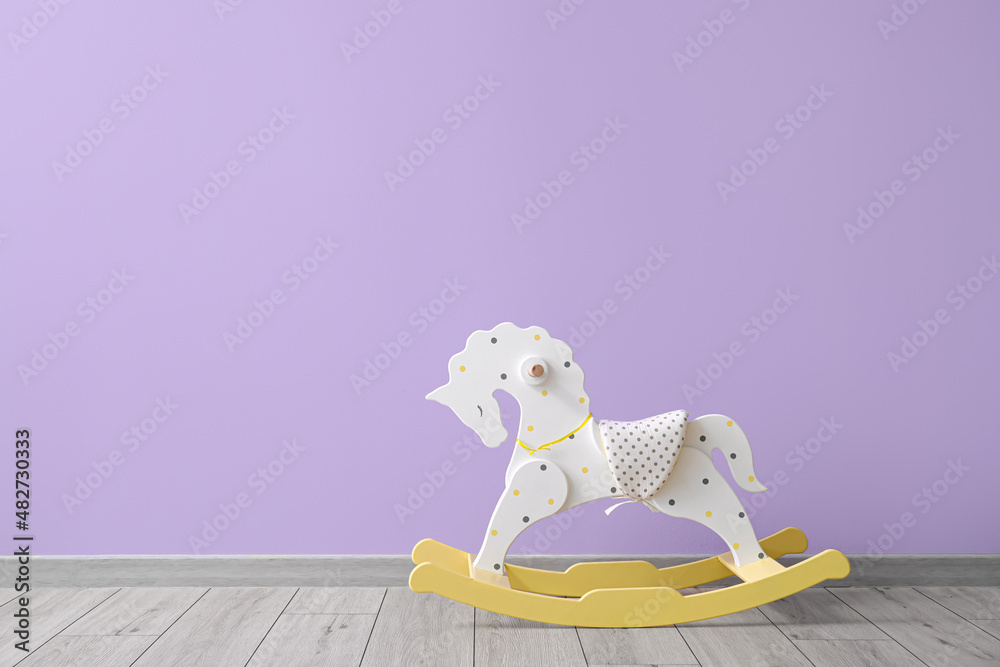 White rocking horse near color wall