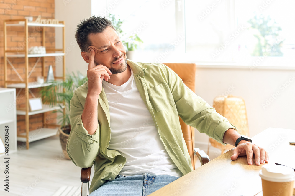 Handsome man sitting at table in office