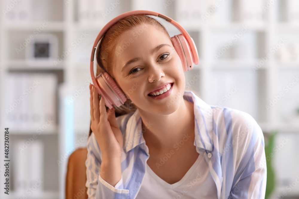 Young woman listening to music in office