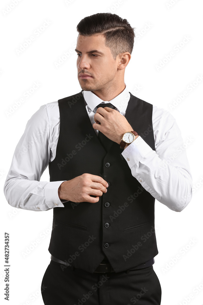 Gentleman in stylish clothes adjusting tie on white background