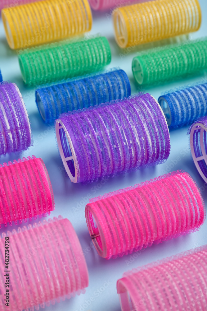 Set of hair curlers on blue background, closeup