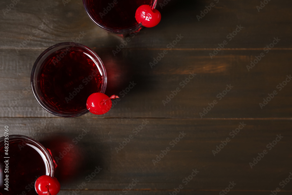 Glasses of tasty Manhattan cocktail on brown wooden background