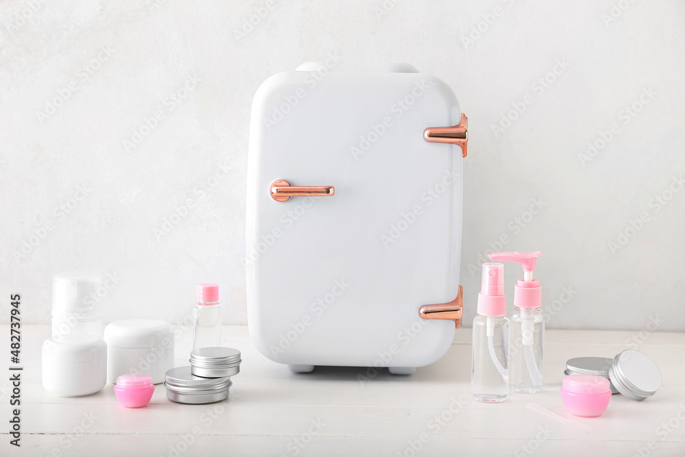 Small refrigerator and cosmetic products on light table