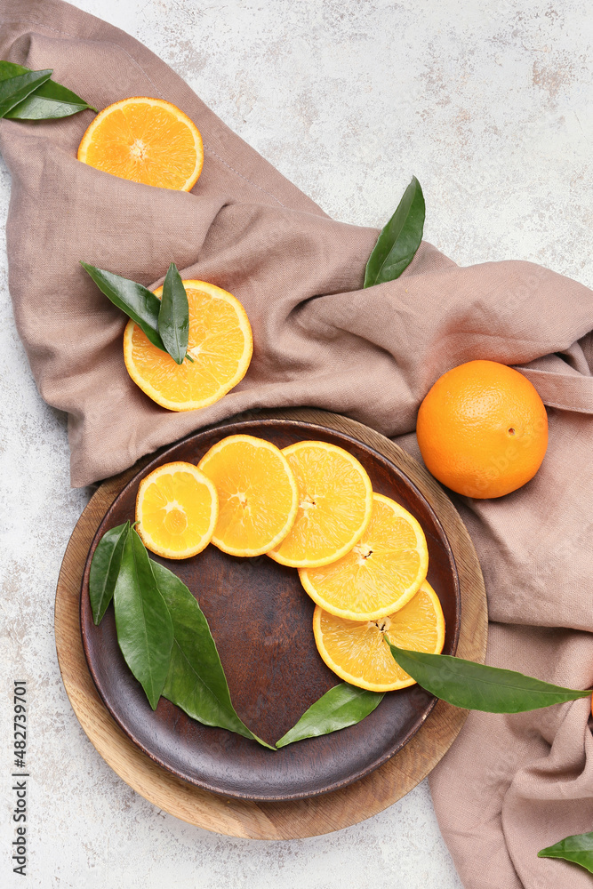 Plates with slices of juicy orange on light background