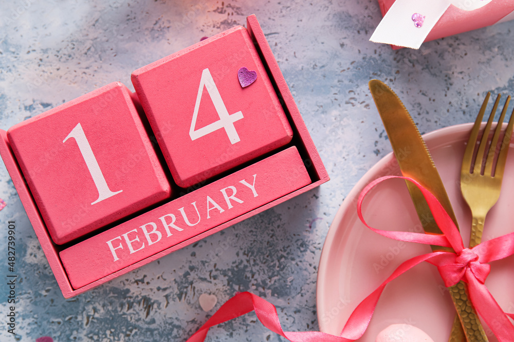 Calendar with date of Valentines Day and table setting on blue background