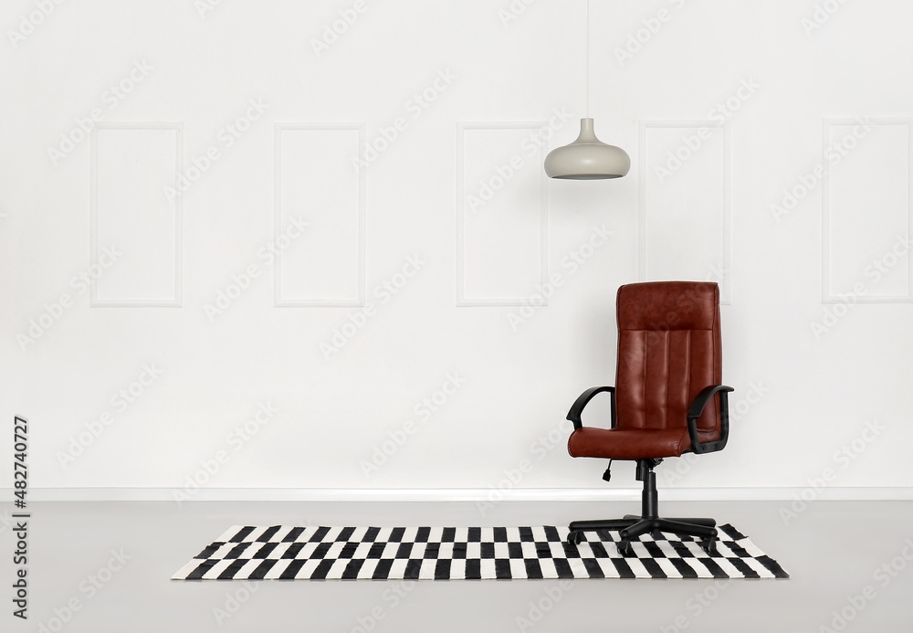 Office chair, carpet and hanging lamp near light wall