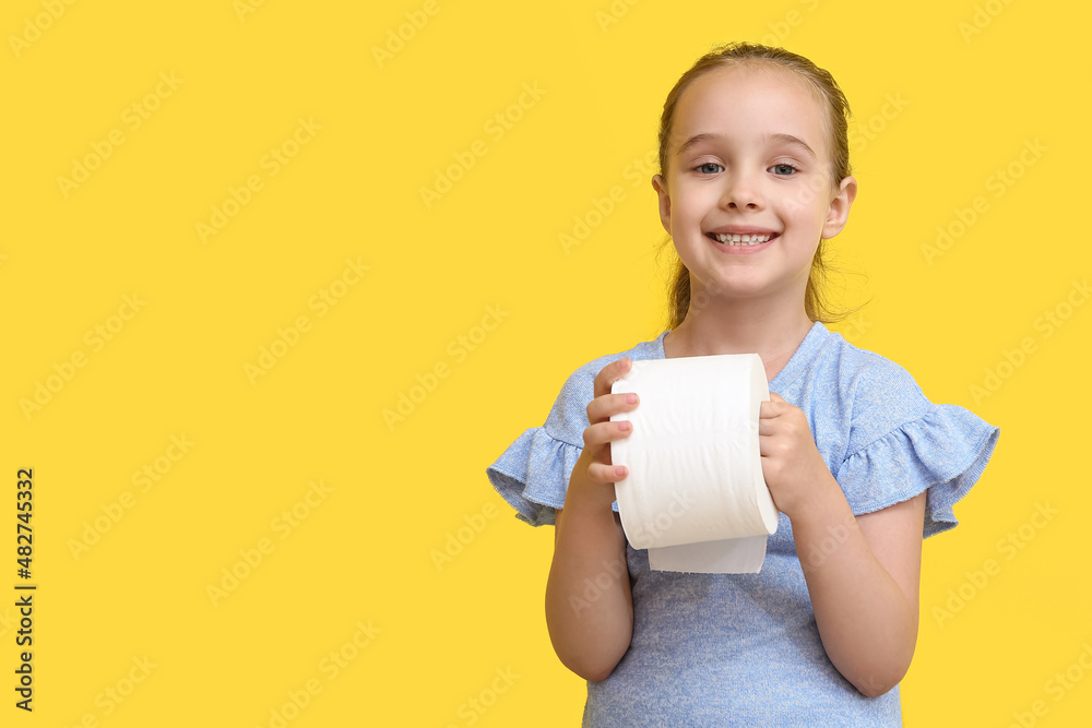 Funny little girl with toilet paper on yellow background