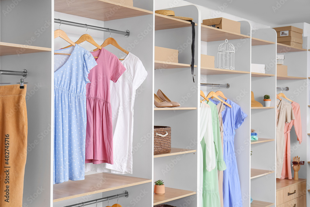 Wardrobe with stylish female clothes and accessories in room