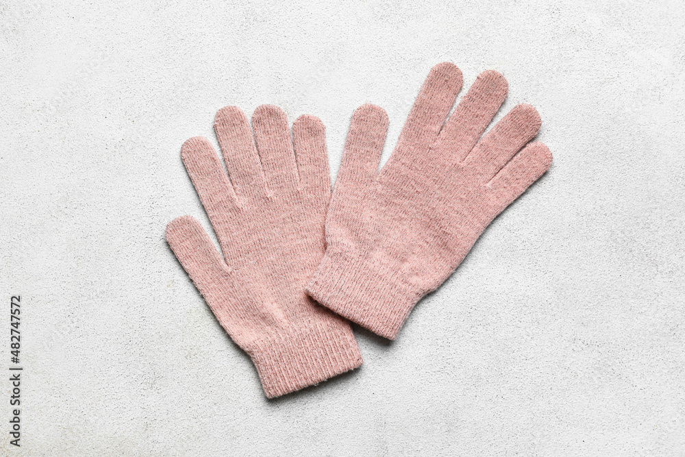 Pair of warm gloves on light background