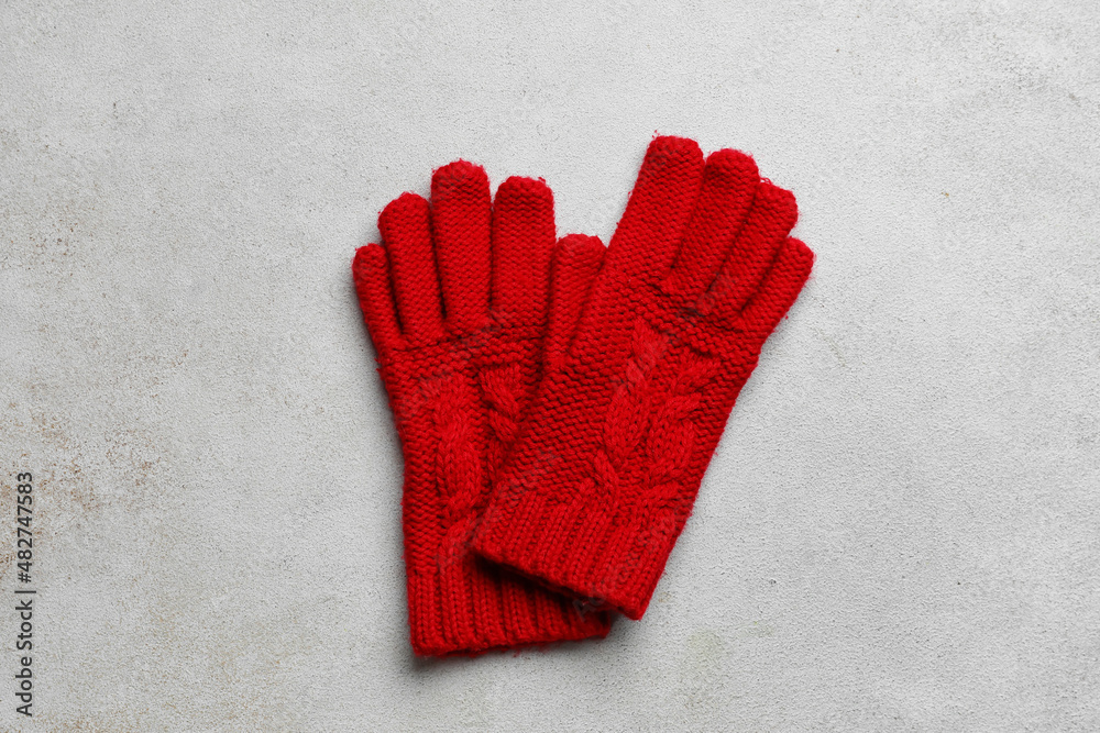 Pair of knitted gloves on light background