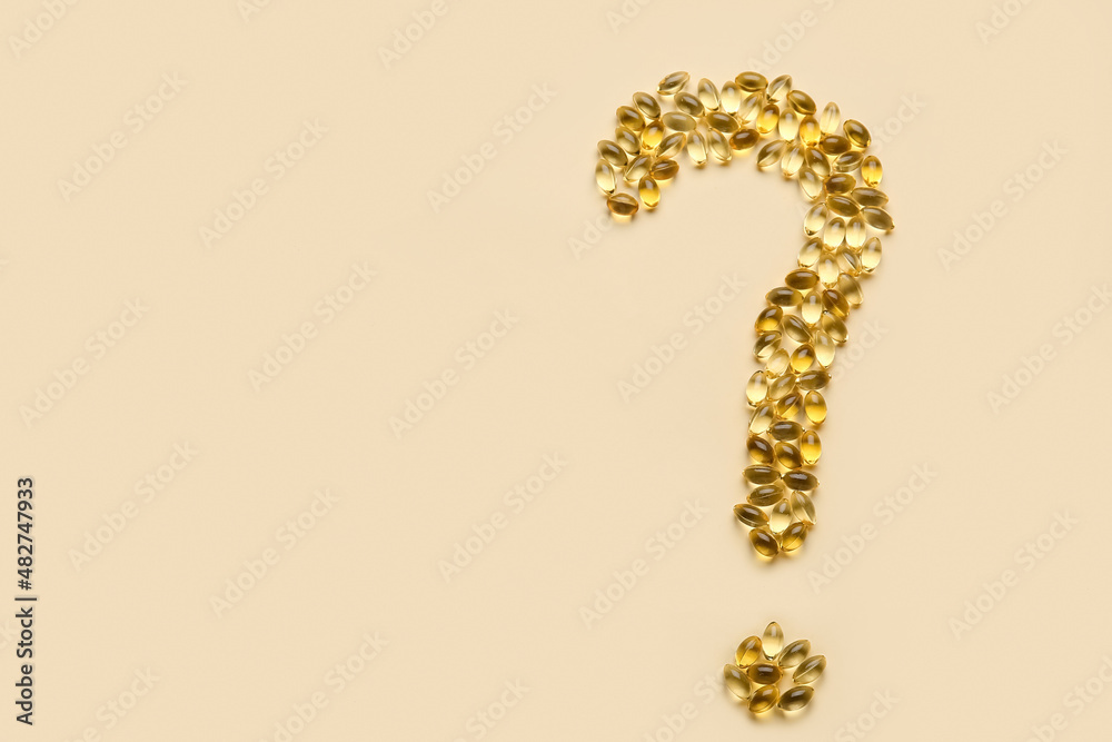 Question mark made of fish oil pills on color background