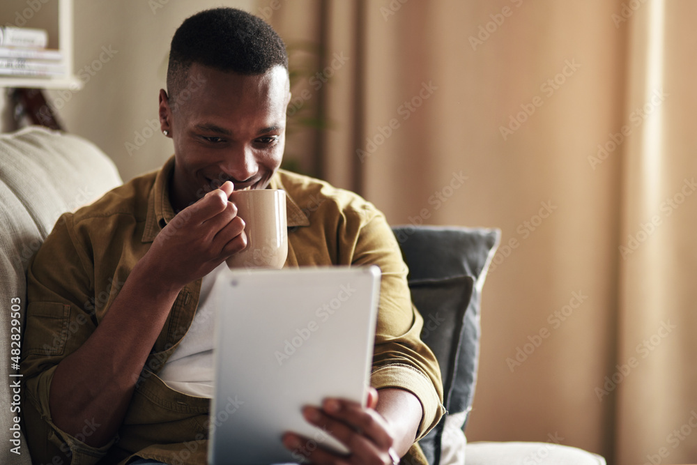 Social media is too interesting today. Cropped shot of a handsome young man drinking coffee while us