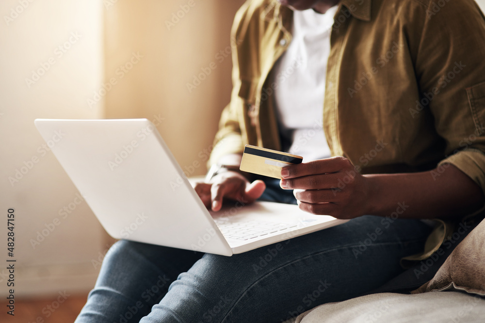 Spoil yourself, you deserve it. Cropped shot of an unrecognizable man using a laptop and a credit ca