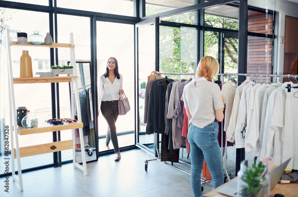 Checking out the new boutique. Shot of two young women shopping in a clothing store.