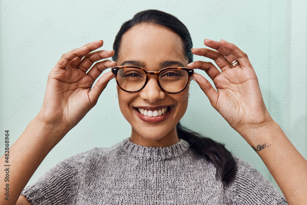 Healthy eyes are happy eyes. Shot of a young woman buying a new pair of glasses at an optometrist st