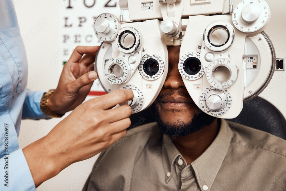 Which is better 1 or 2. Shot of an optometrist examining her patients eyes with an optical refractor