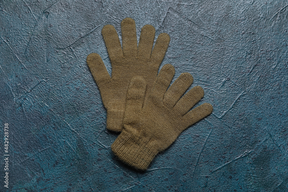 Pair of warm gloves on dark color background