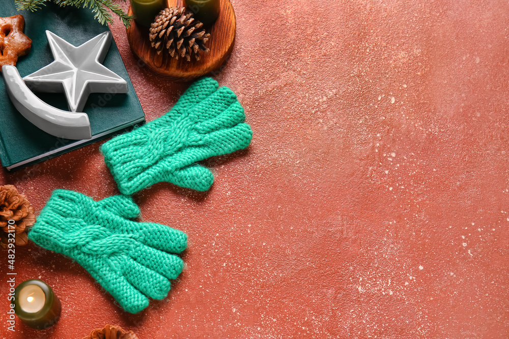 Warm gloves, burning candle, book and Christmas decor on red background