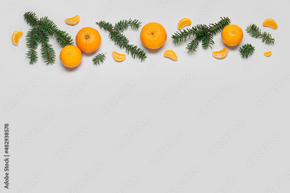 Composition with fir branches and ripe tangerines on white background