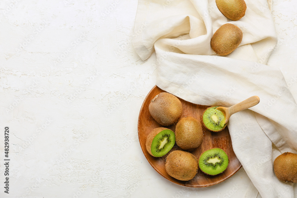 Plate with fresh kiwi on white background