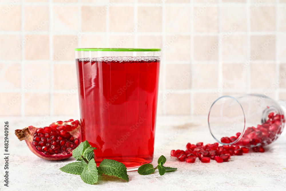 Glass of delicious pomegranate juice on table