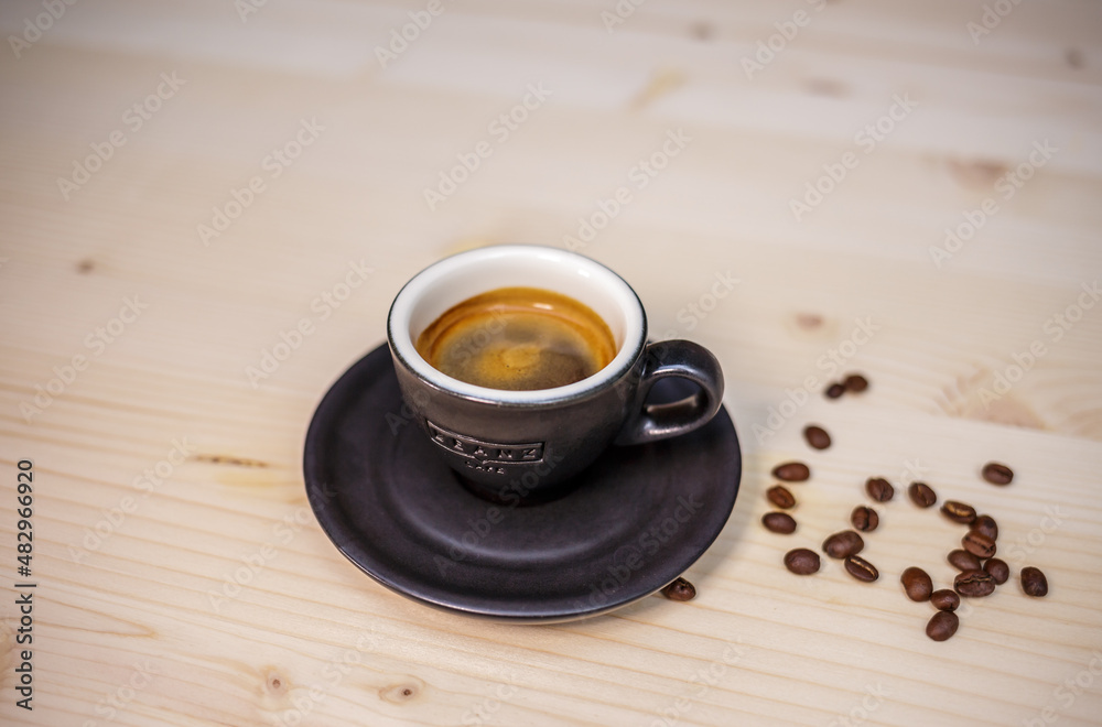 Espresso coffee on table with wood background and coffee beans