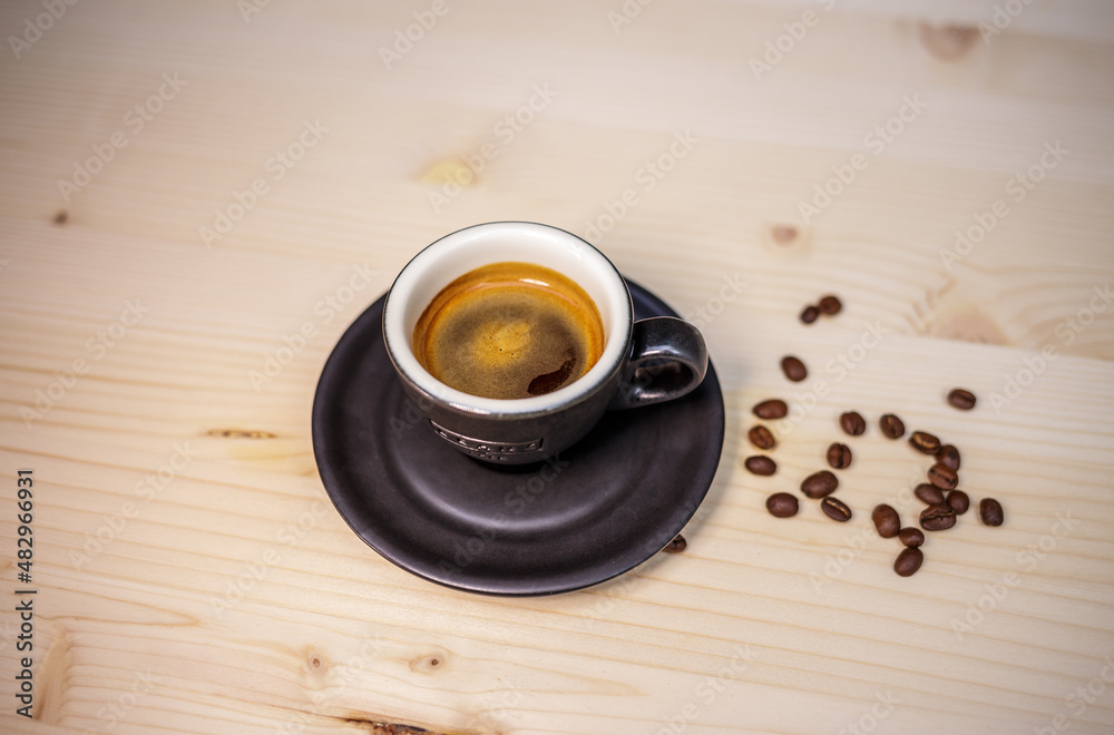 Espresso coffee on table with wood background and coffee beans