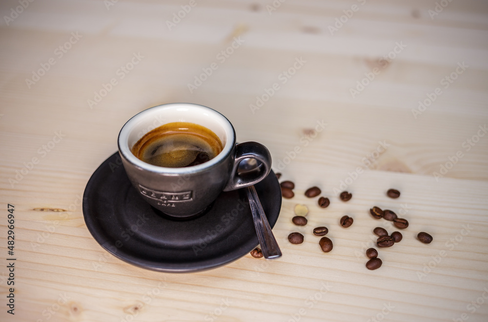 Espresso coffee on table with wood background and coffee beans