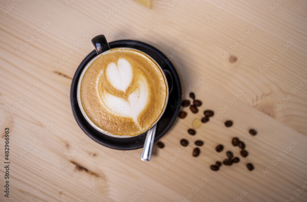 Espresso coffee with milk on table with wood background and coffee beans