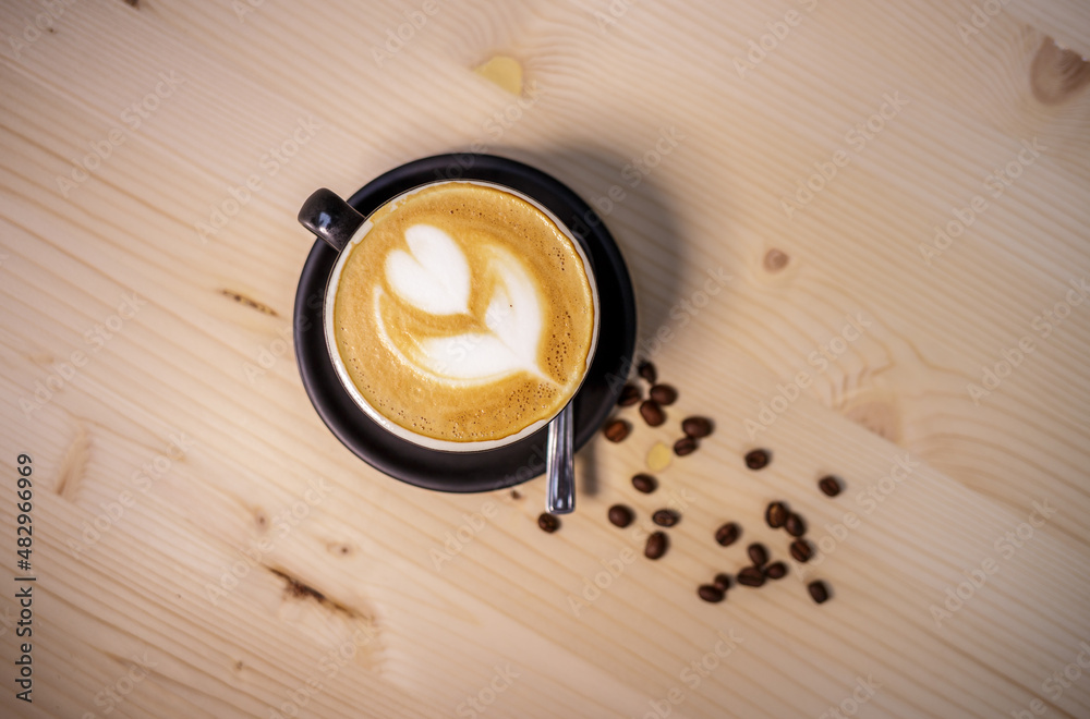 Espresso coffee with milk on table with wood background and coffee beans