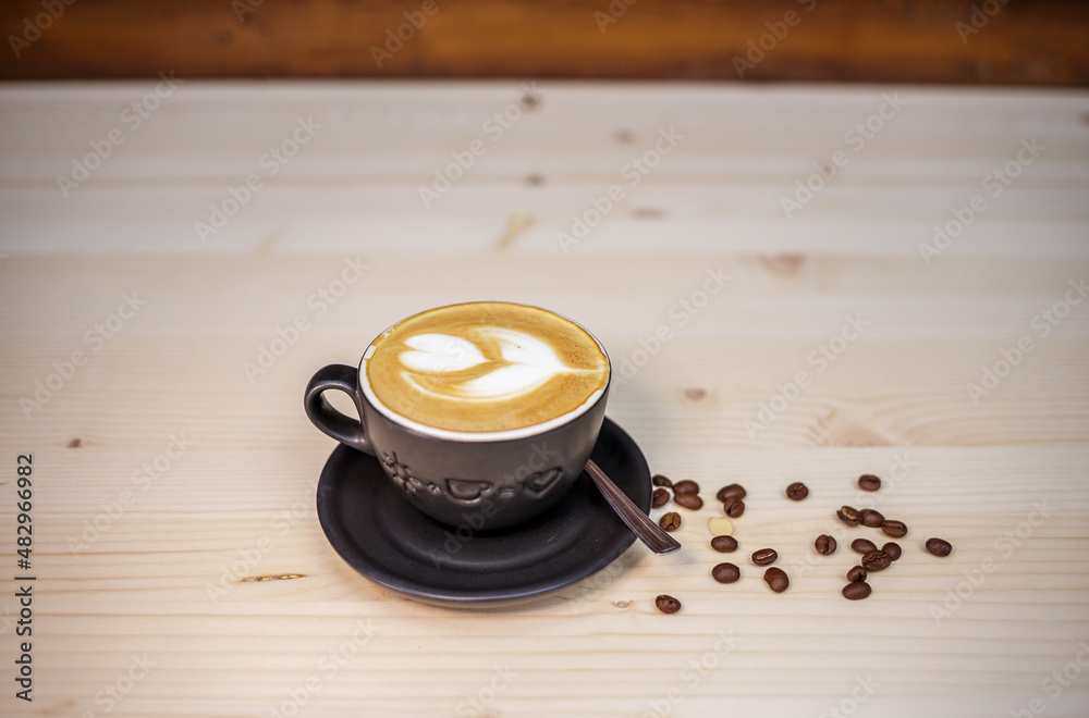 Espresso coffee with milk on table with wood background and coffee beans