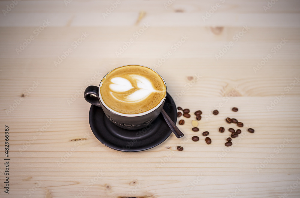 Espresso coffee with milk on table with wood background and coffee beans