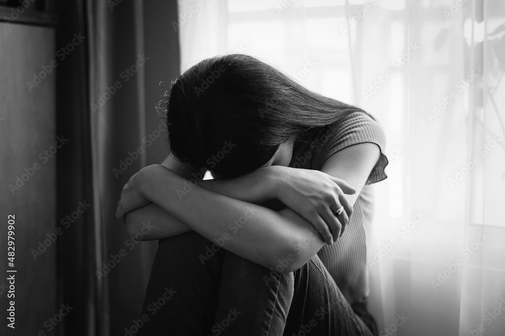 woman sit Depression Standing by window and anxiety