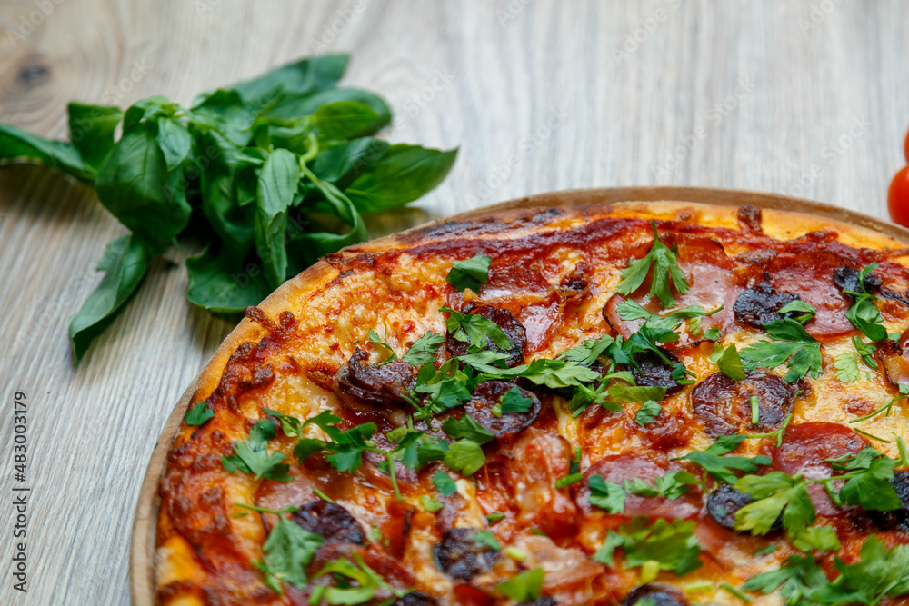 pizza with sausage, ham, salami and parsley