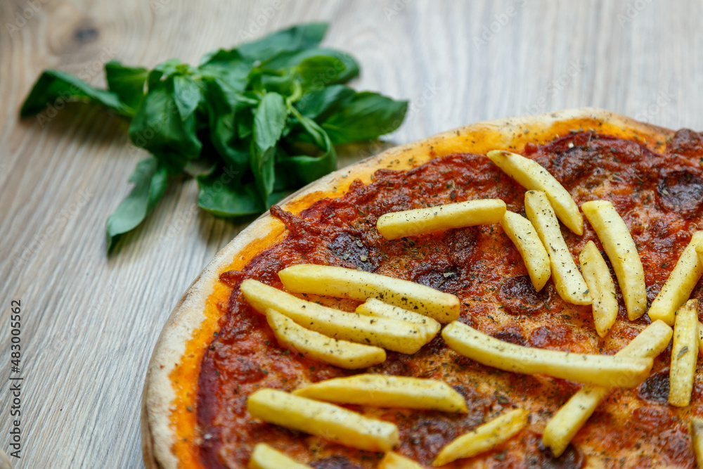 pizza with hot sausage and french fries on tomato sauce