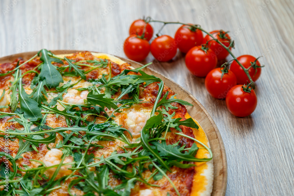 pizza with shrimp, mozzarella, arugula and tomato sauce