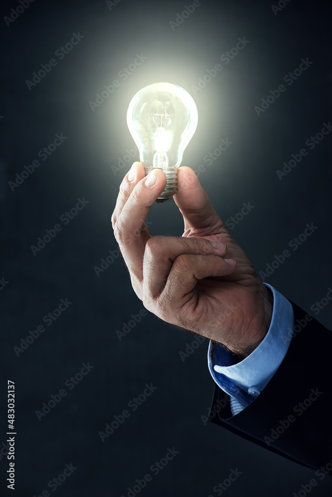 I finally have a good idea. Shot of a hand holding a lightbulb on a black background.