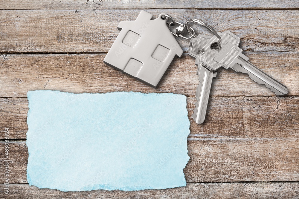 Key, toy house and torn paper on the desk