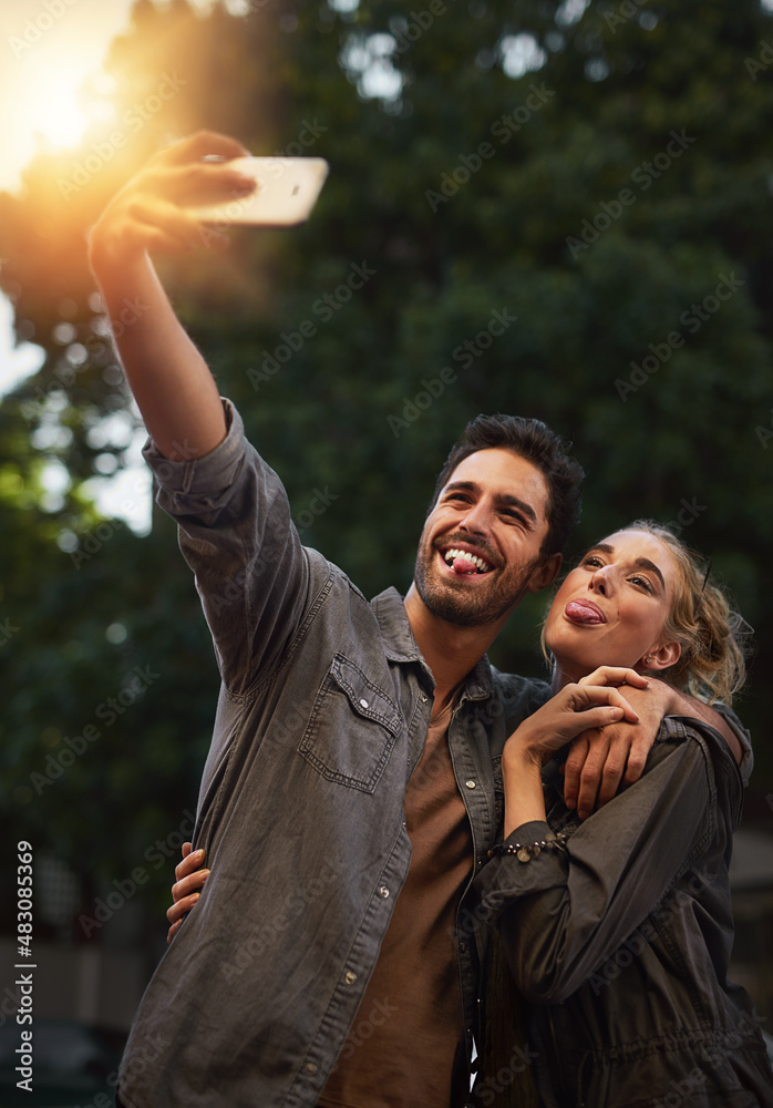 We love taking selfies. Shot of a young couple taking a selfie in the city.