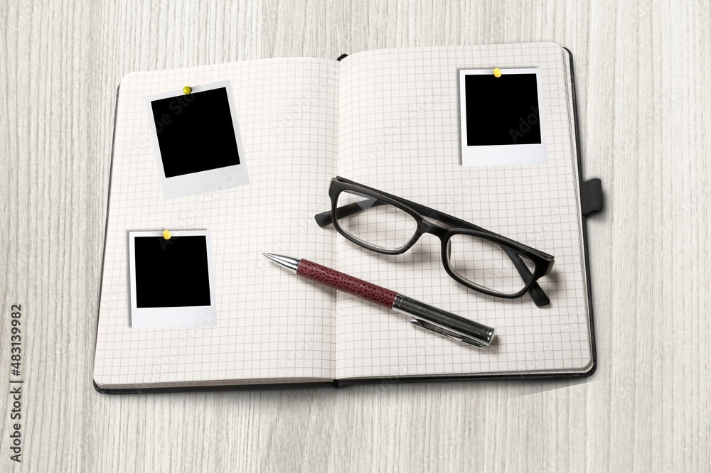 Photo album spread with empty photo frames on the desk