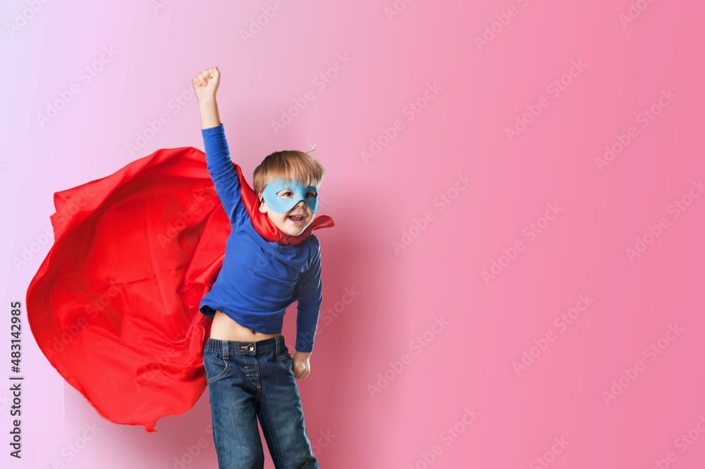 Portrait of little kid. Funny little power superhero kid showing muscles.