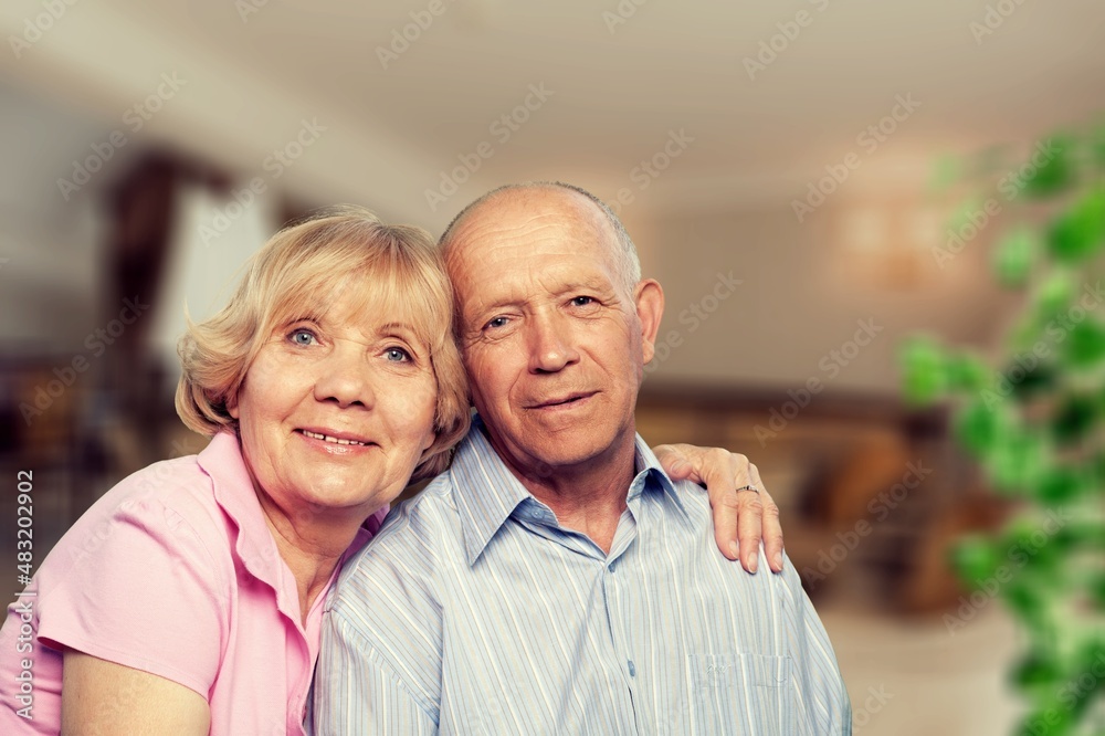 old retired age couple watching TV at home, on sofa couch at living room home